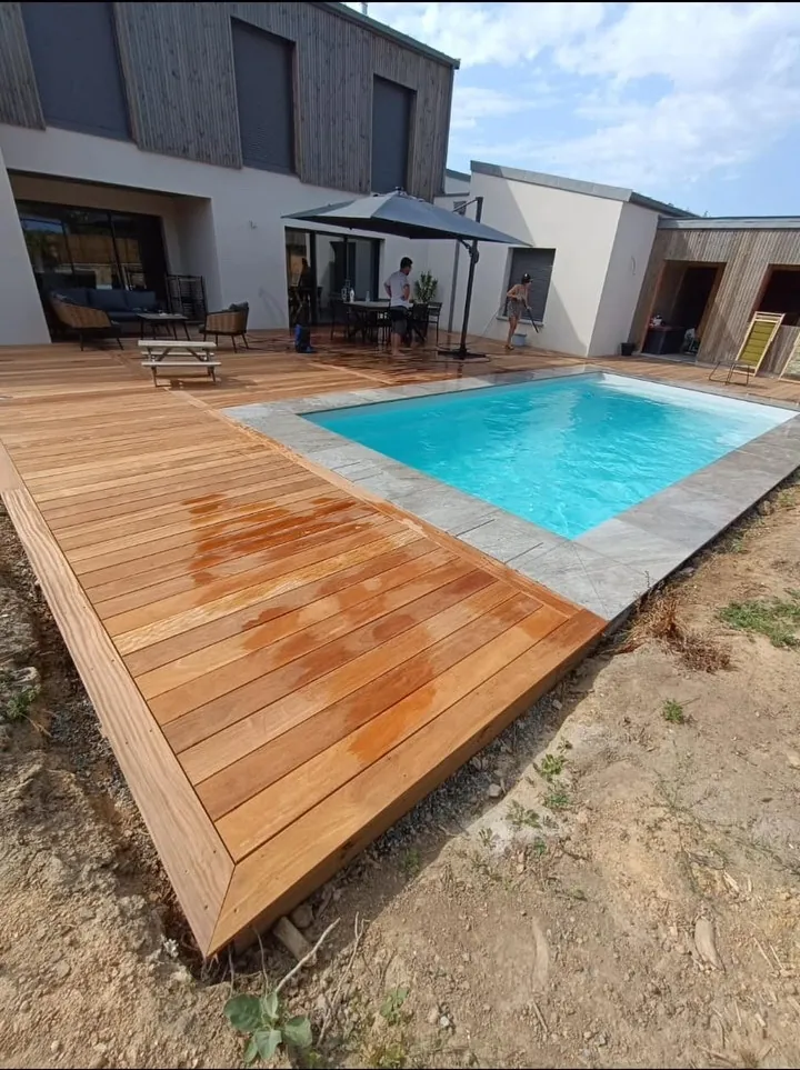Terrasse en bois autour d'une piscine avec aménagement extérieur